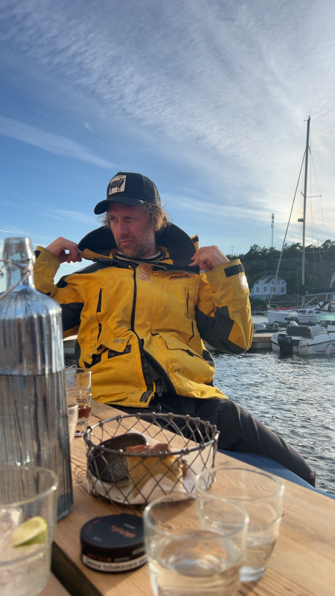 Christen i gul seiljakke ved havnen